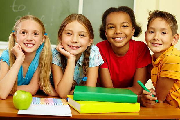 Schülerinnen und Schüler mit Apfel